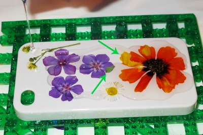 adding clear resin to flowers and a phone cover