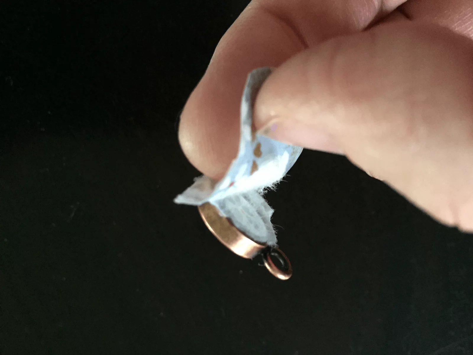 peeling paper away from back of bezel pendant