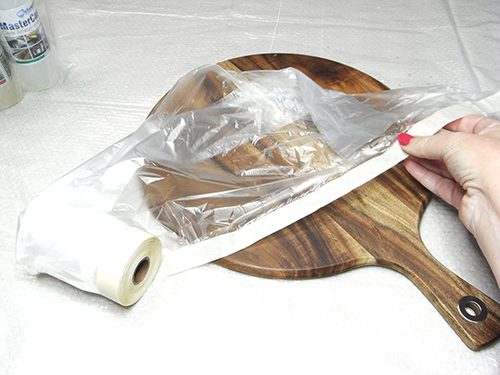 cover cheese board with plastic and secure with tape