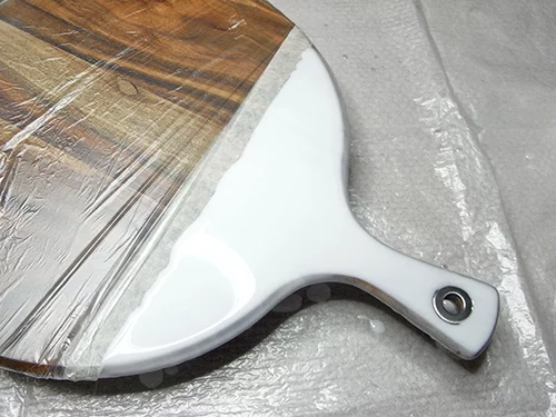 white layer of resin on cheese board handles