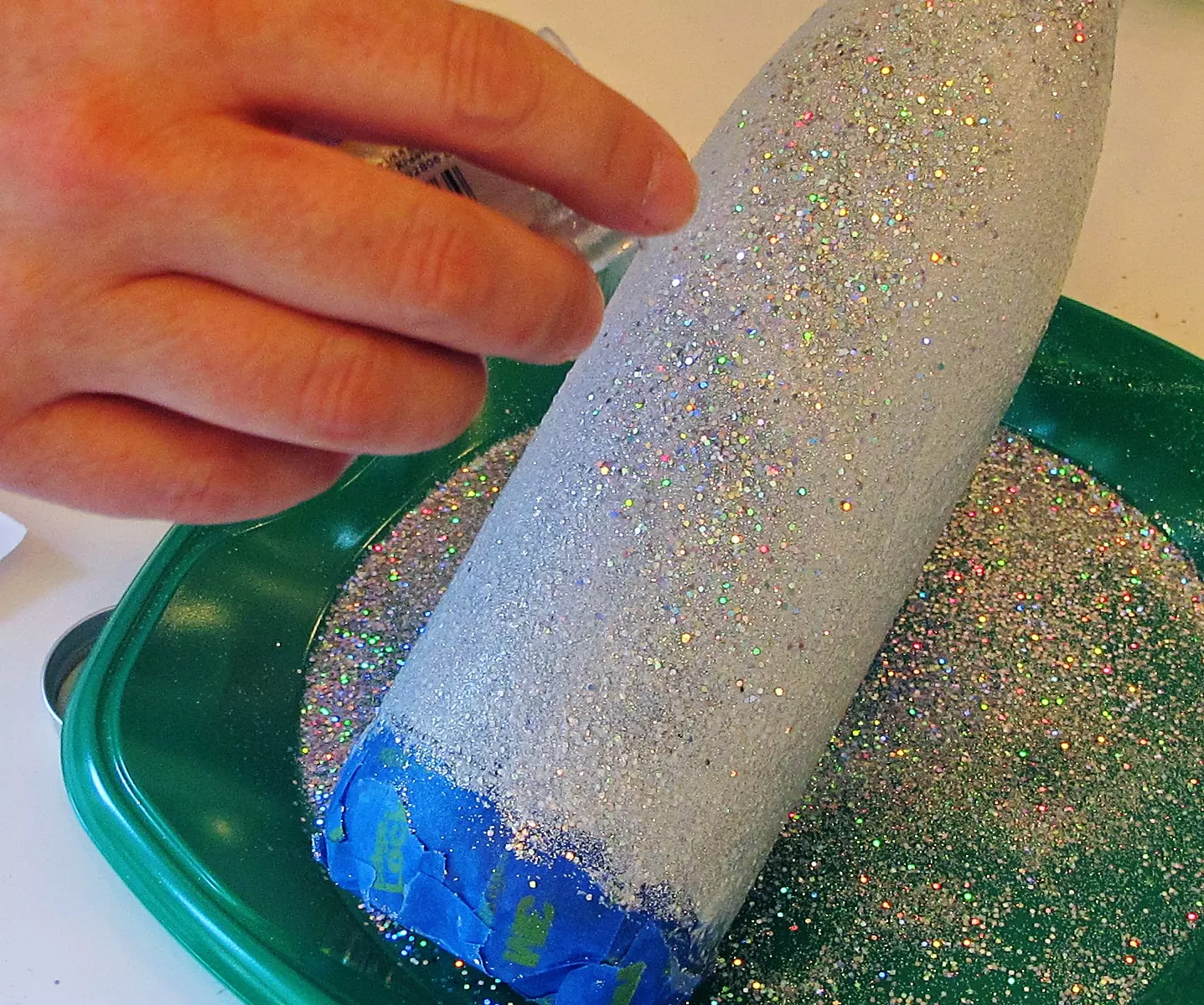 applying a layer of glitter to a stainless steel tumbler