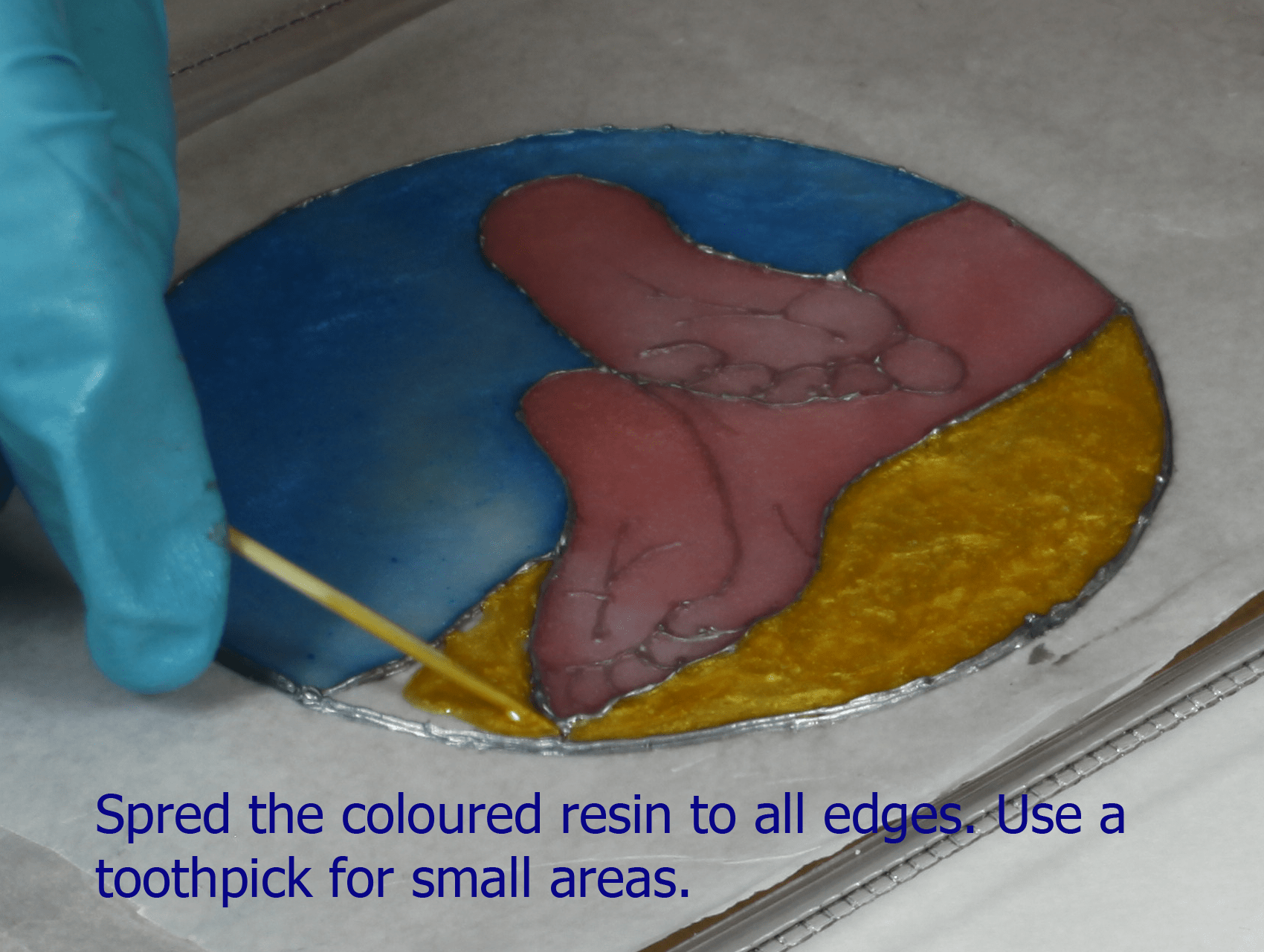 spreading colored resin to create a faux stained glass