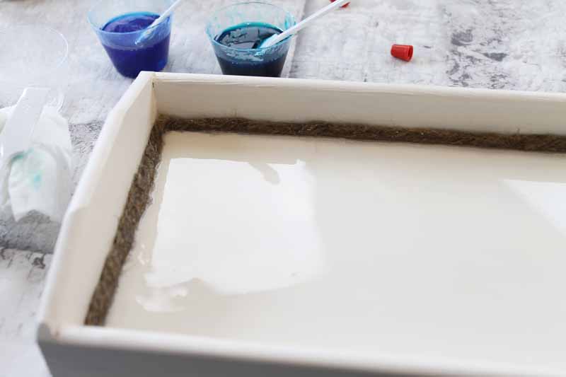 adding resin to a wooden tray