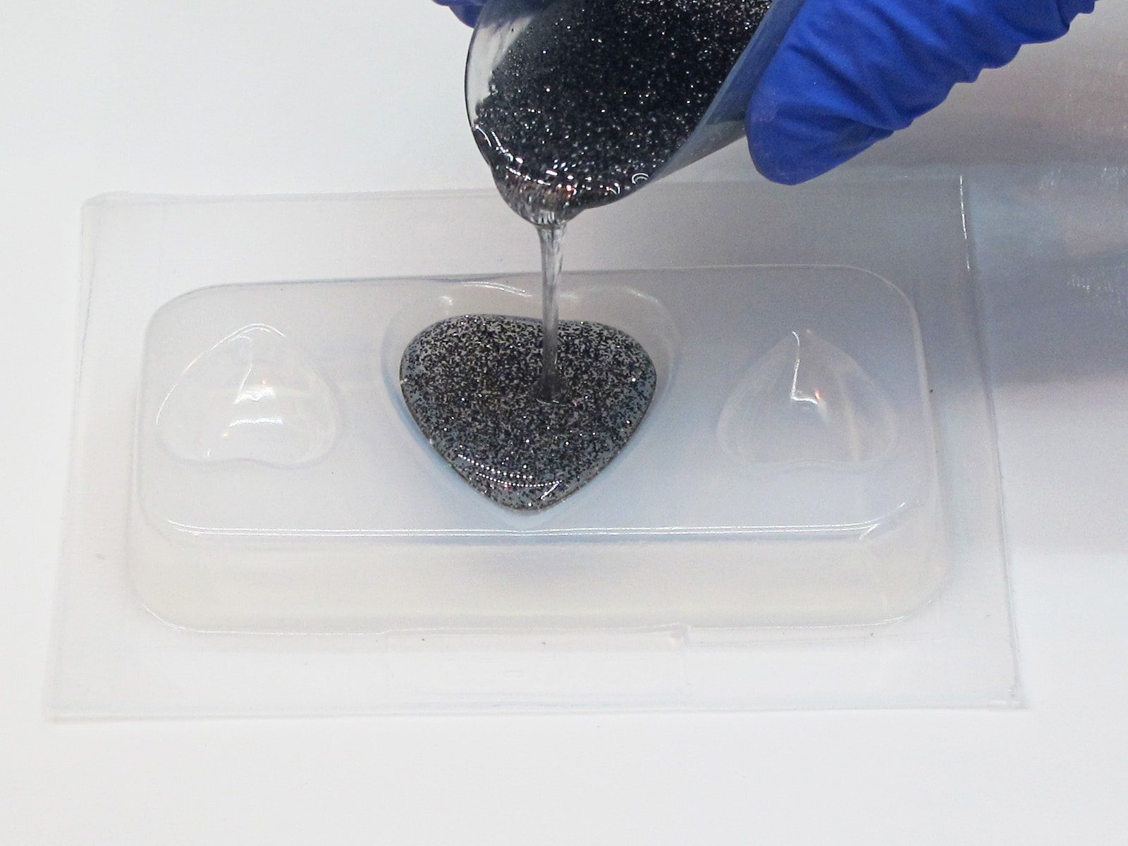 pouring resin into a plastic heart mold