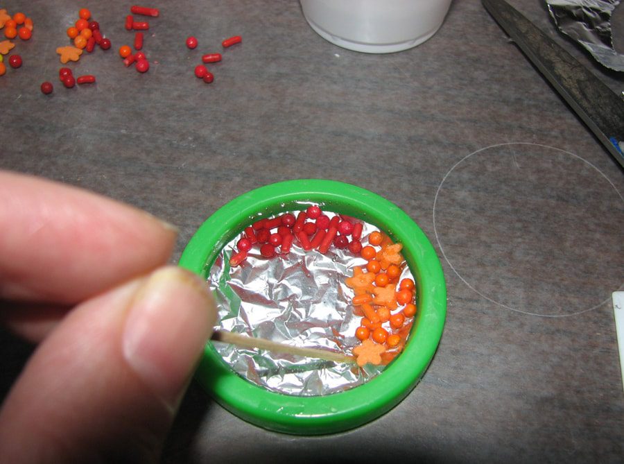 Placing candy sprinkles in resin pendant