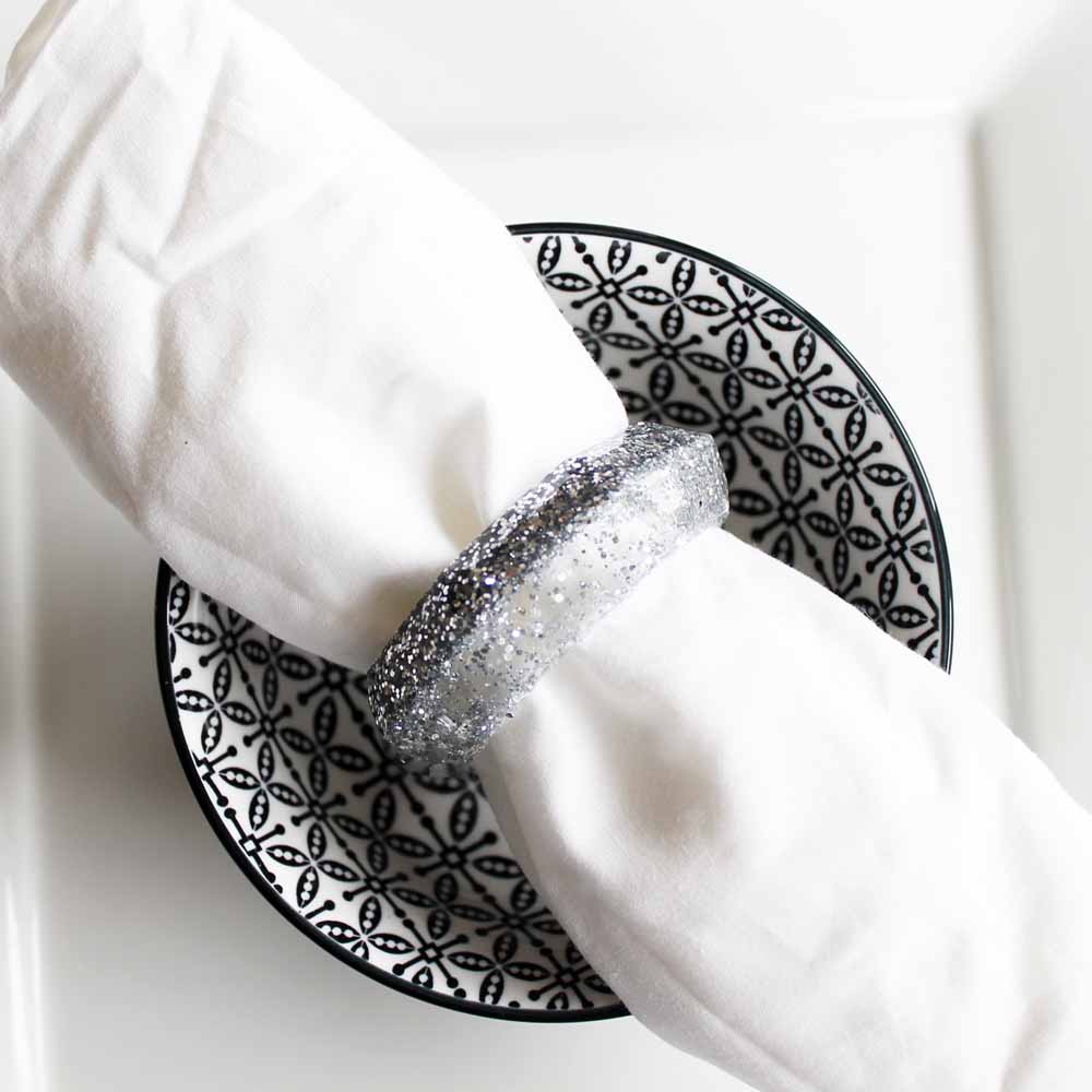 silver glitter resin napkin rings silver on black and white dish