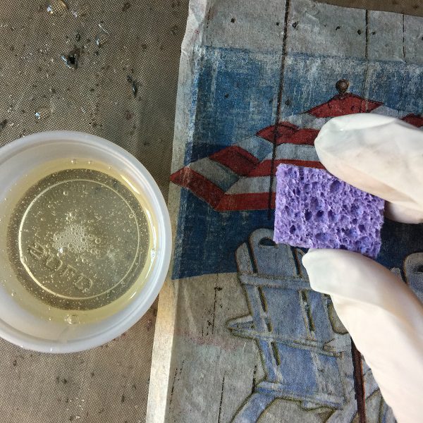 spread thin layer of resin on tag with piece of kitchen sponge