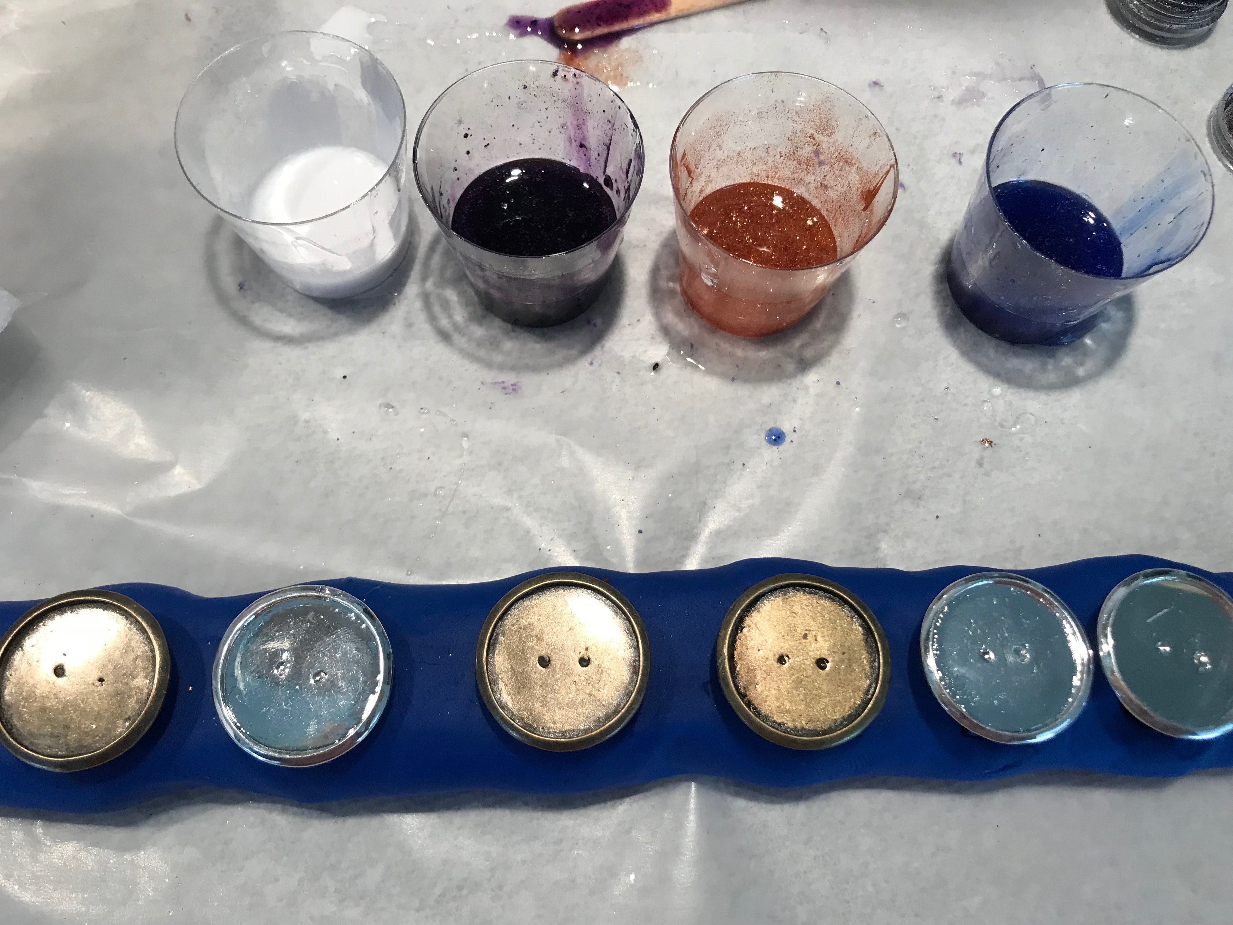 Pearl. deep purple, bronze, and deep blue cups of mixed resin in back, rings ready to fill in front