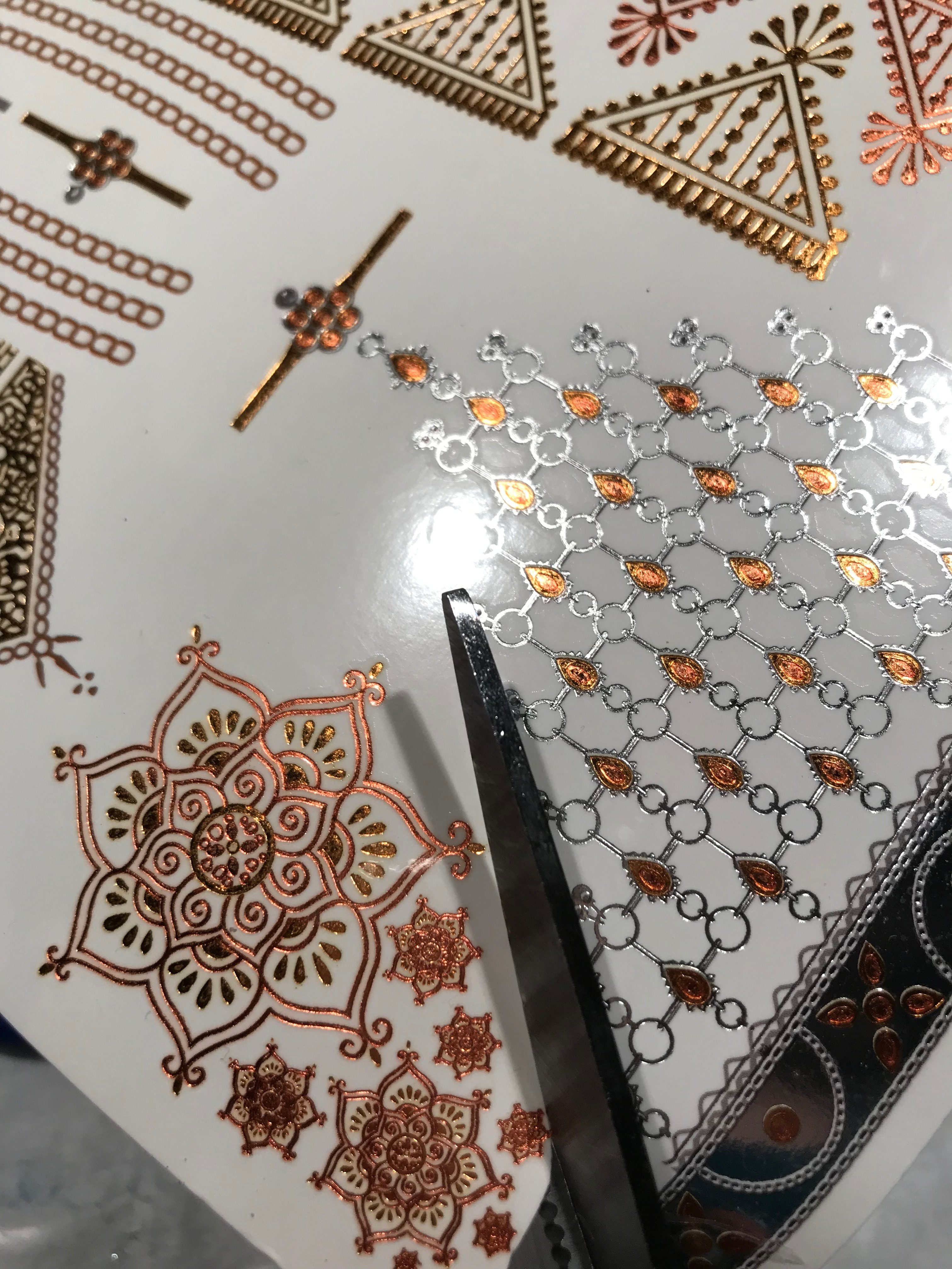 Cutting out gold mandala temporary tattoos to make ring