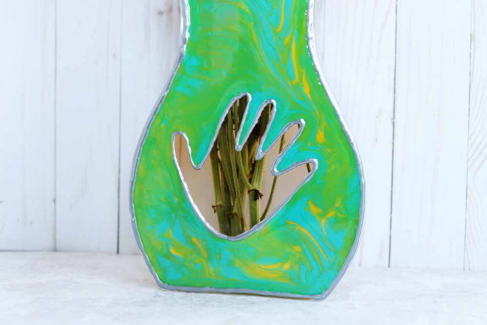 resin painted flat sided vase with child's handprint and flower stems