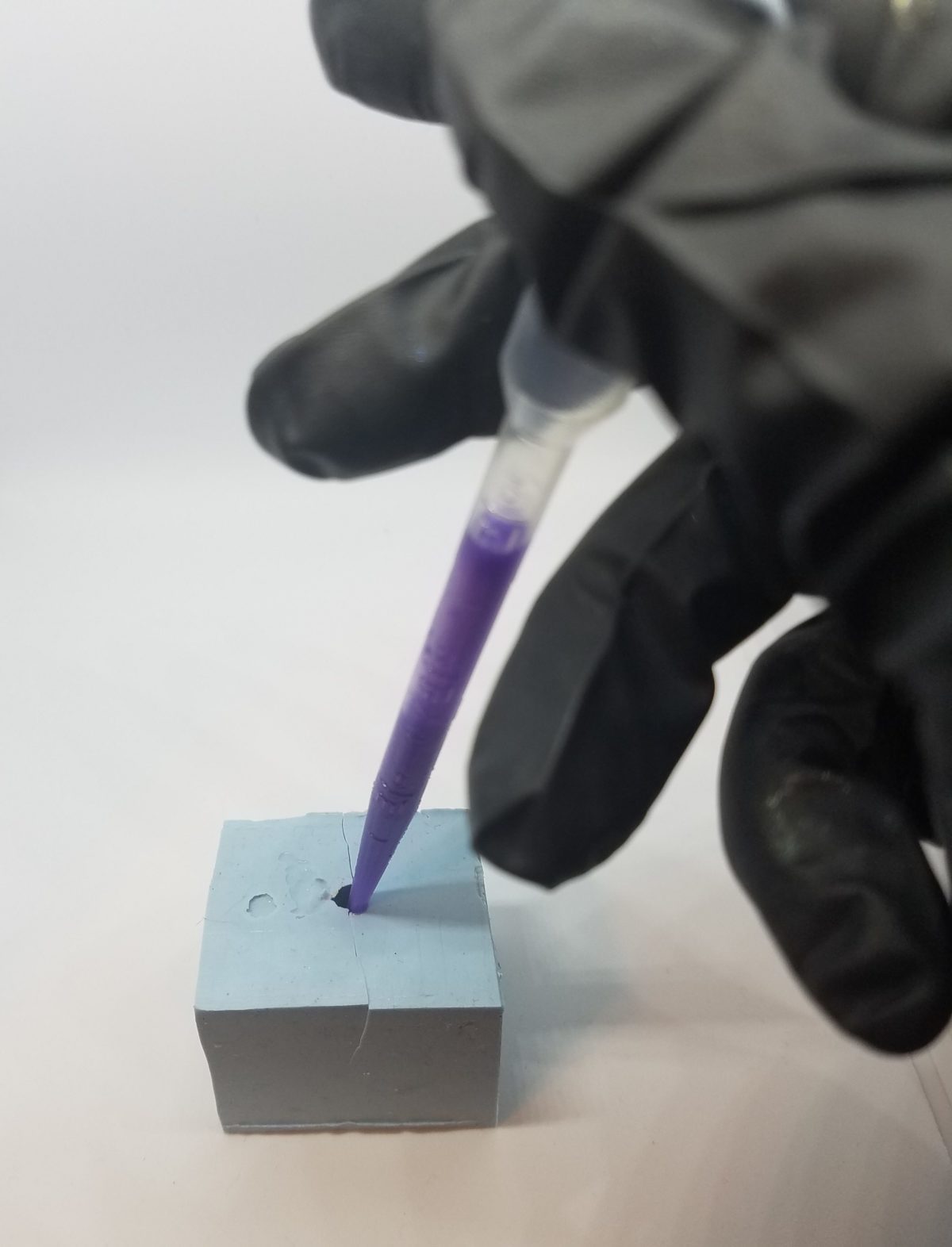 Using a pipette to insert resin into mold