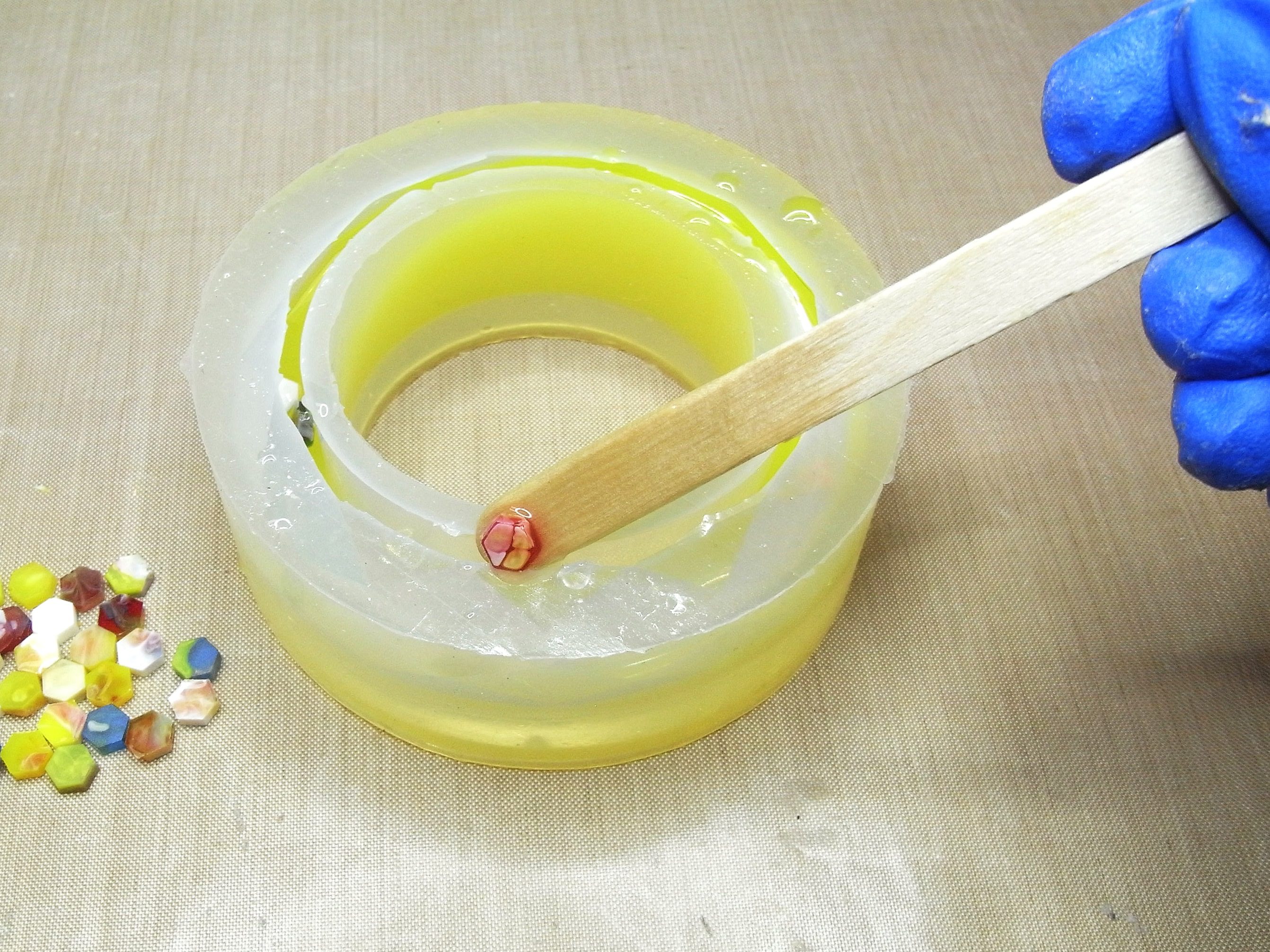 inserting hexagon resin confetti into resin inside bangle mold