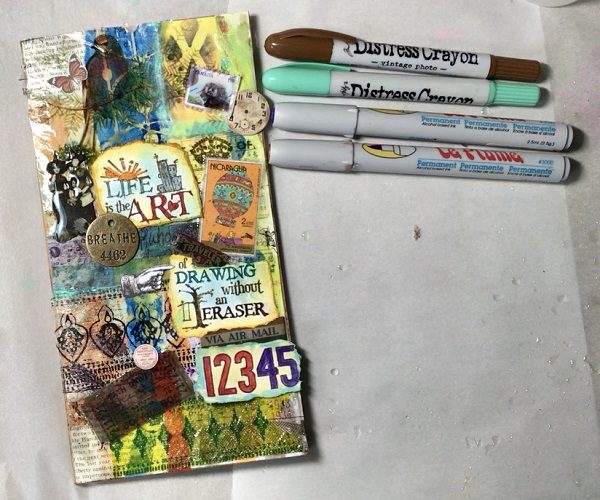 ephemera and marker added to resin art journal cover