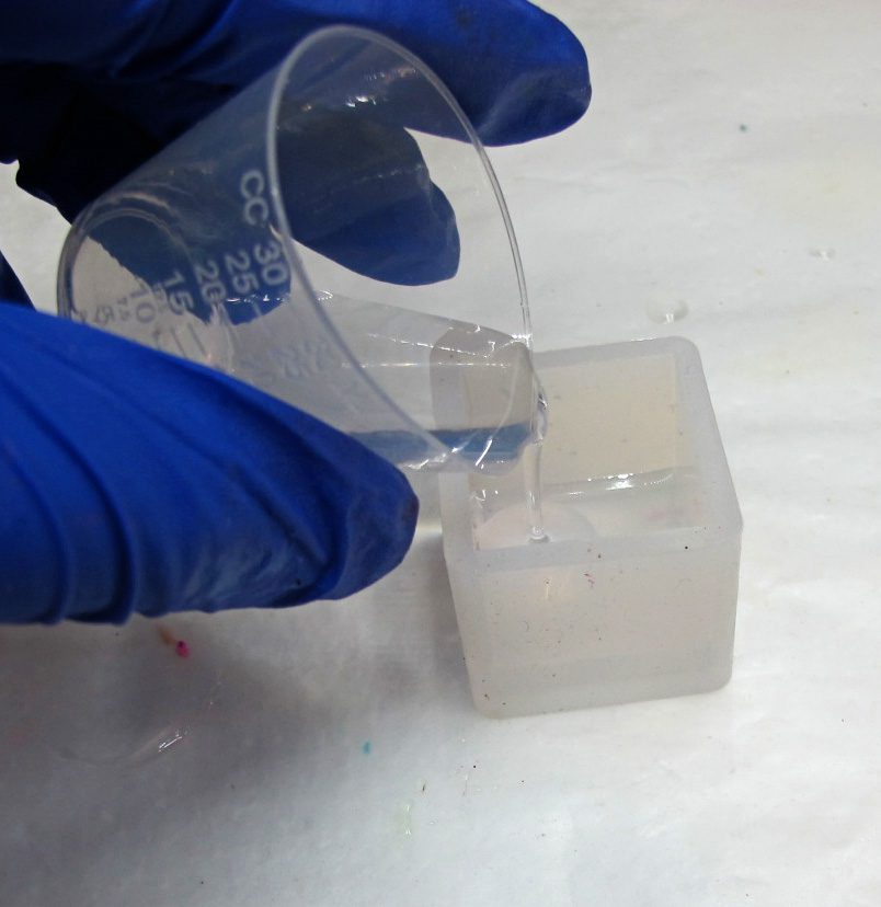 pouring resin into a cube mold