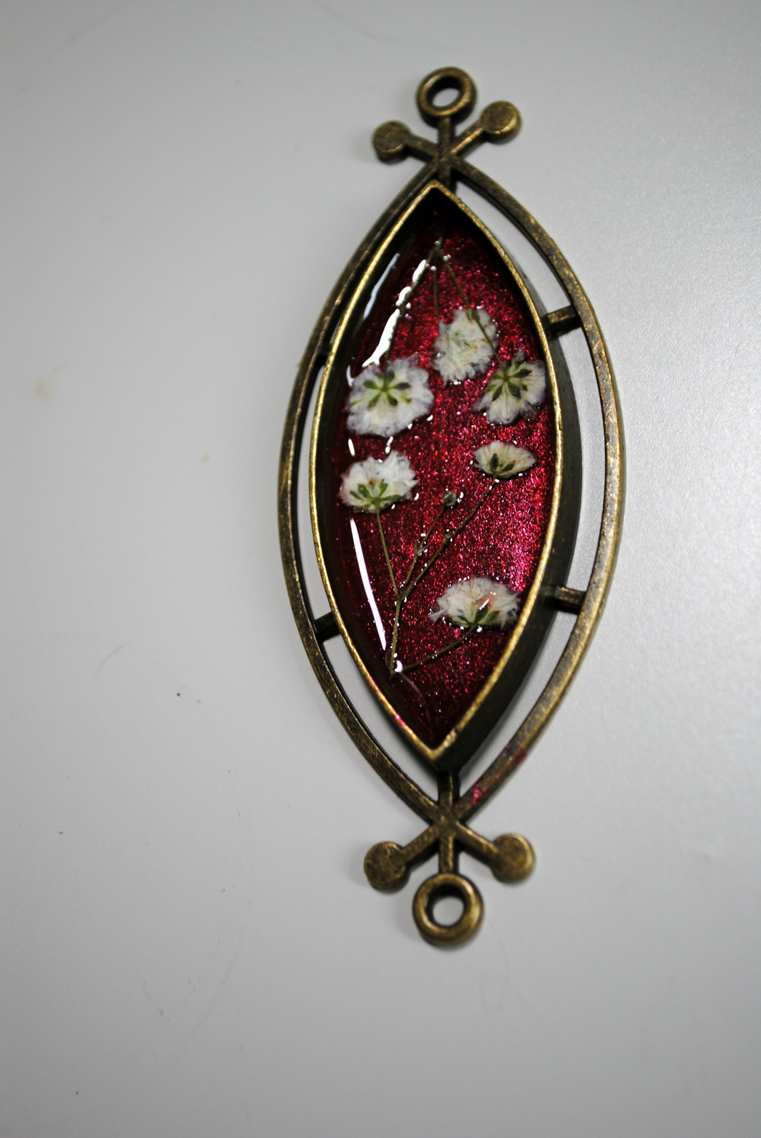 dried baby's breath flower in resin filled jewelry blank