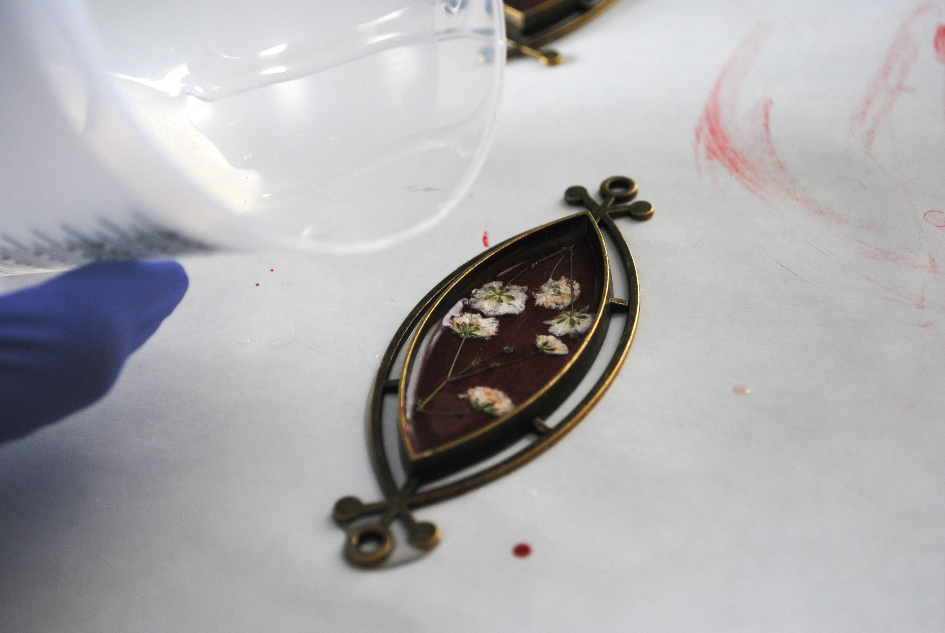 resin being poured into flower resin pendant