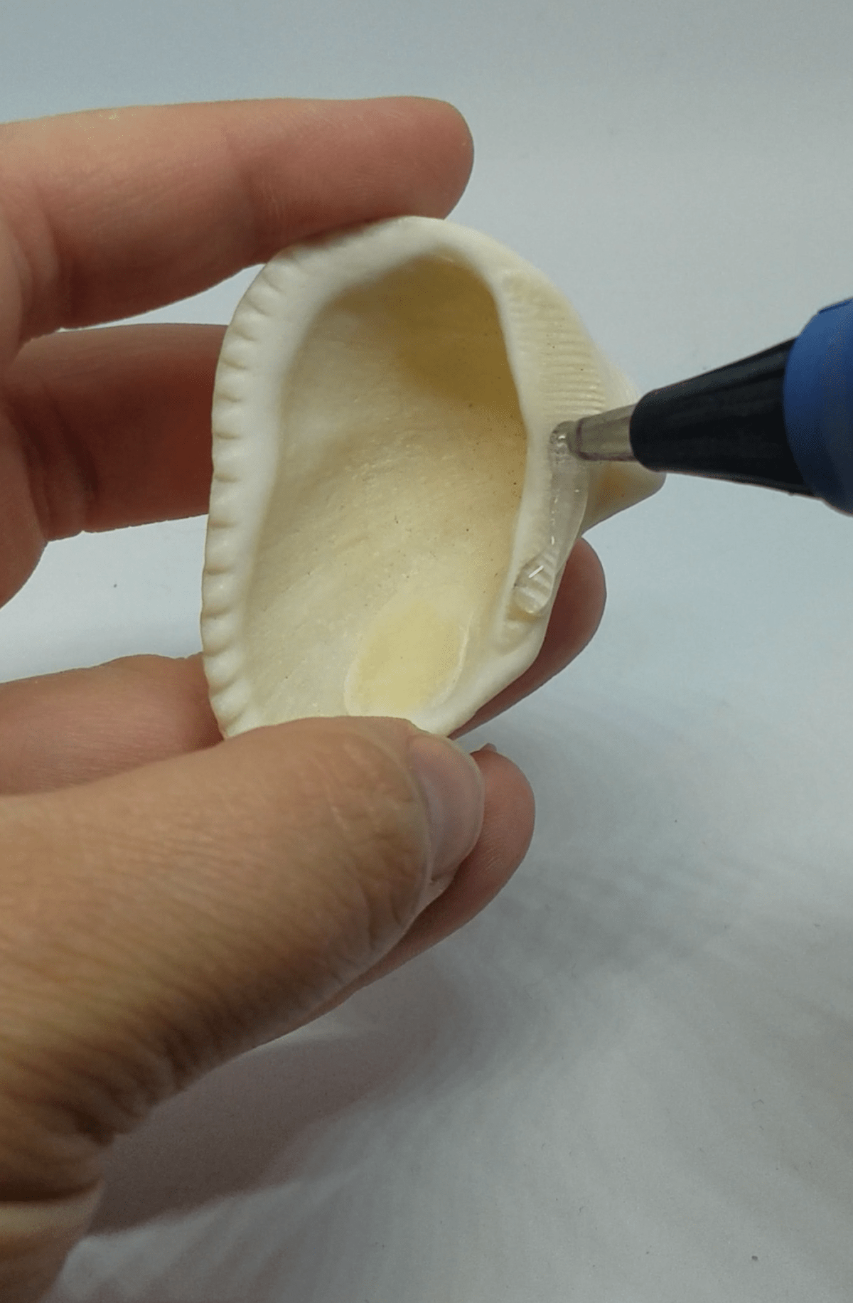 applying hot glue to a resin seashell