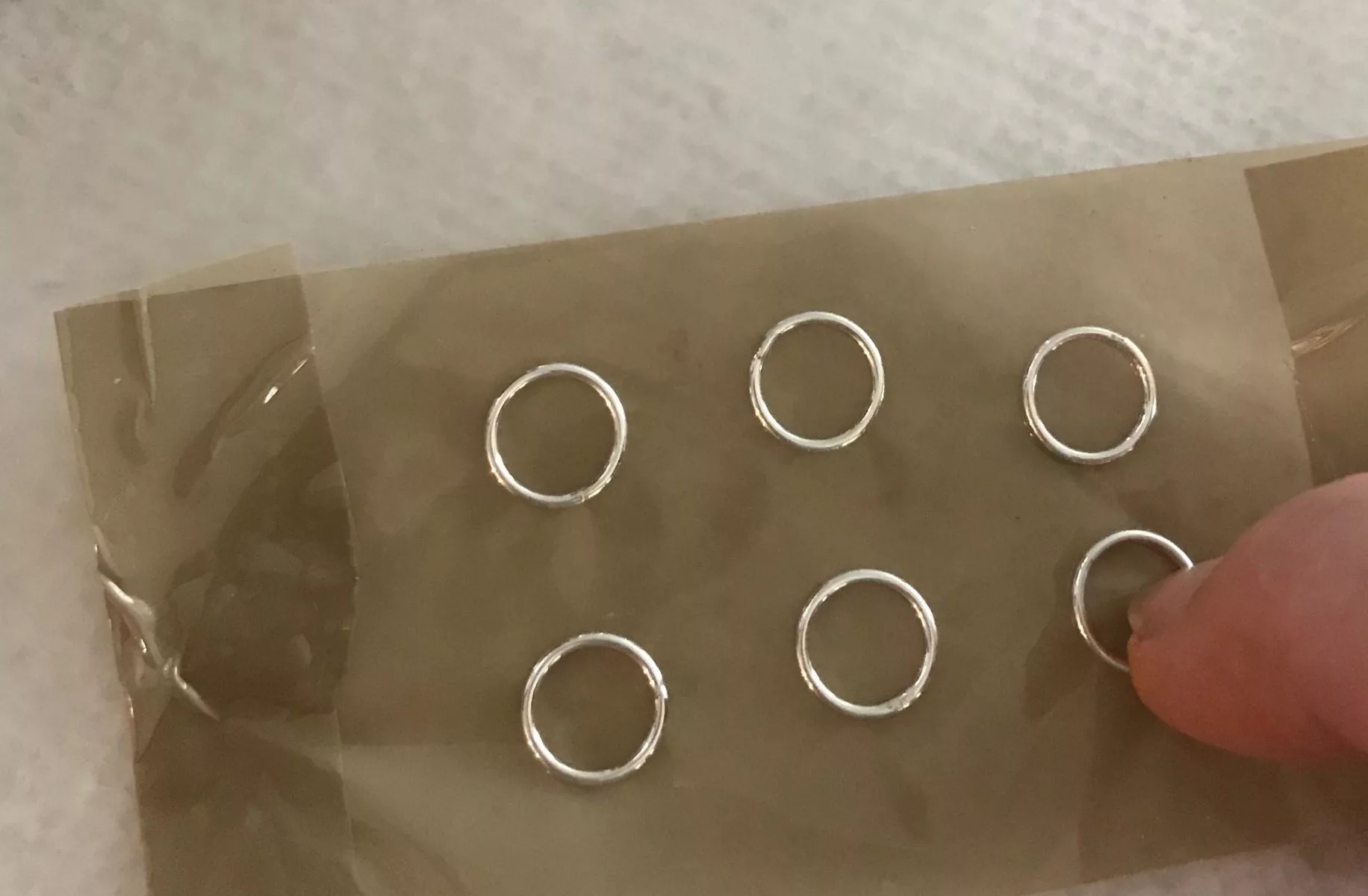 placing silver rings on packing tape