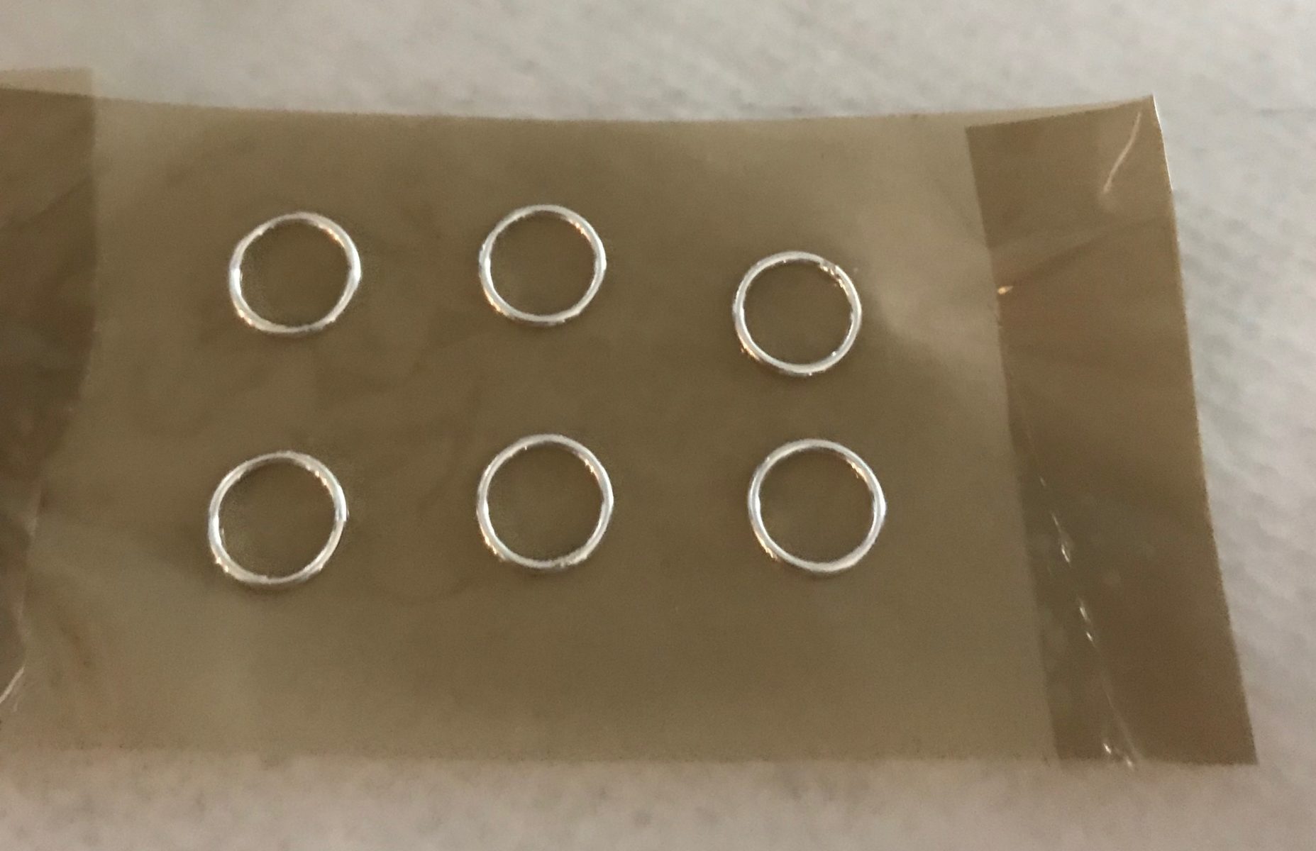 silver jump rings on packing tape
