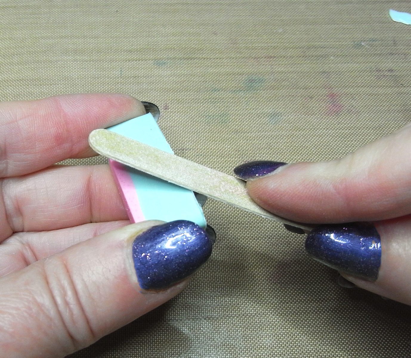 filing epoxy charms with an emery board