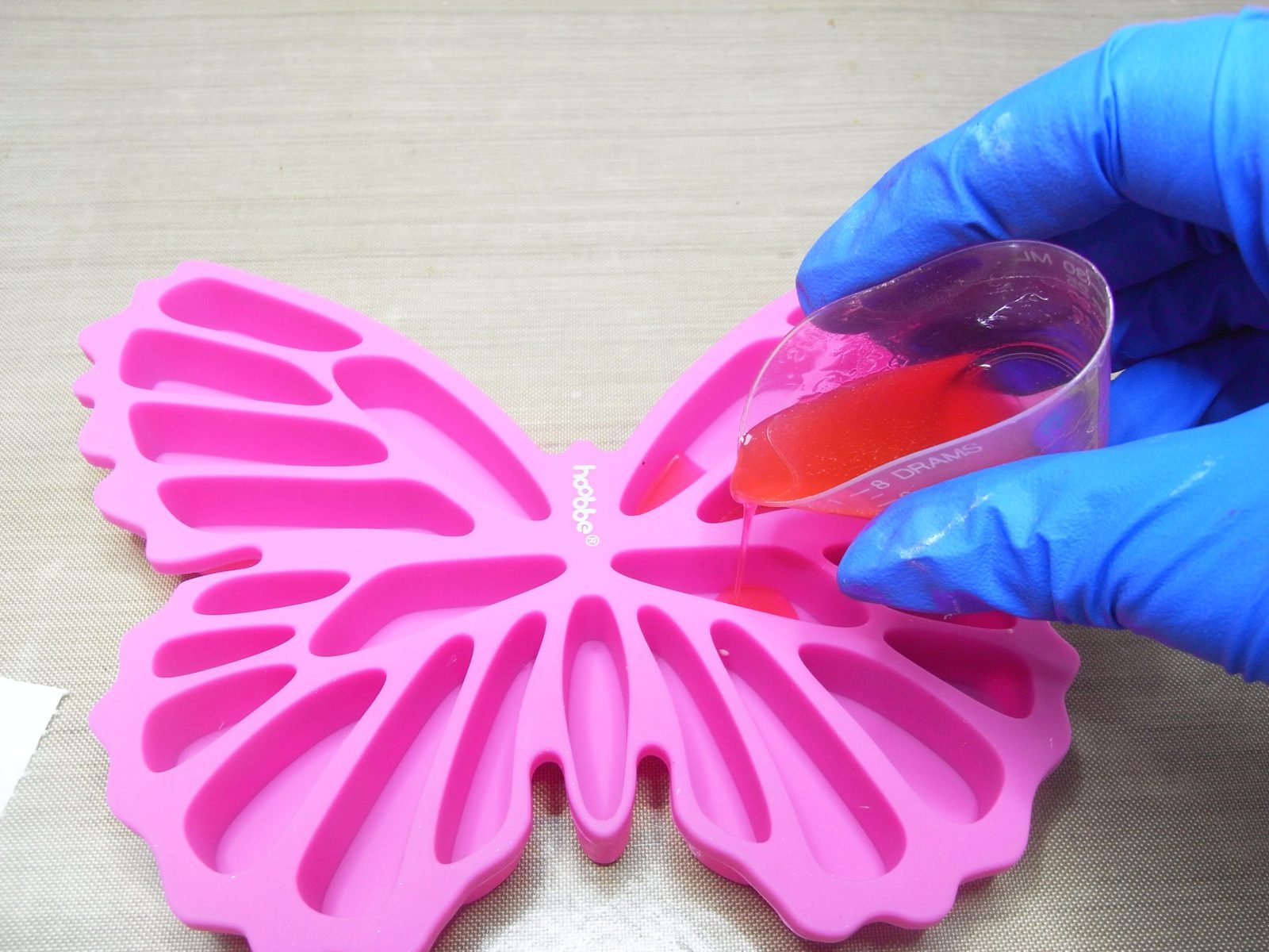 pouring pink resin into a silicone mold