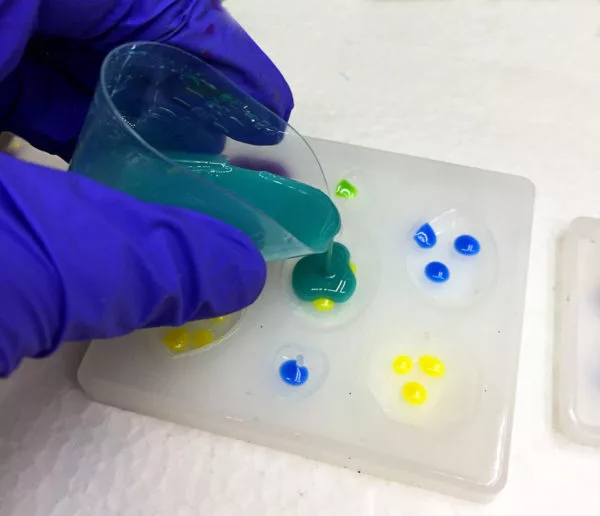 pouring colored resin into a silicone mold