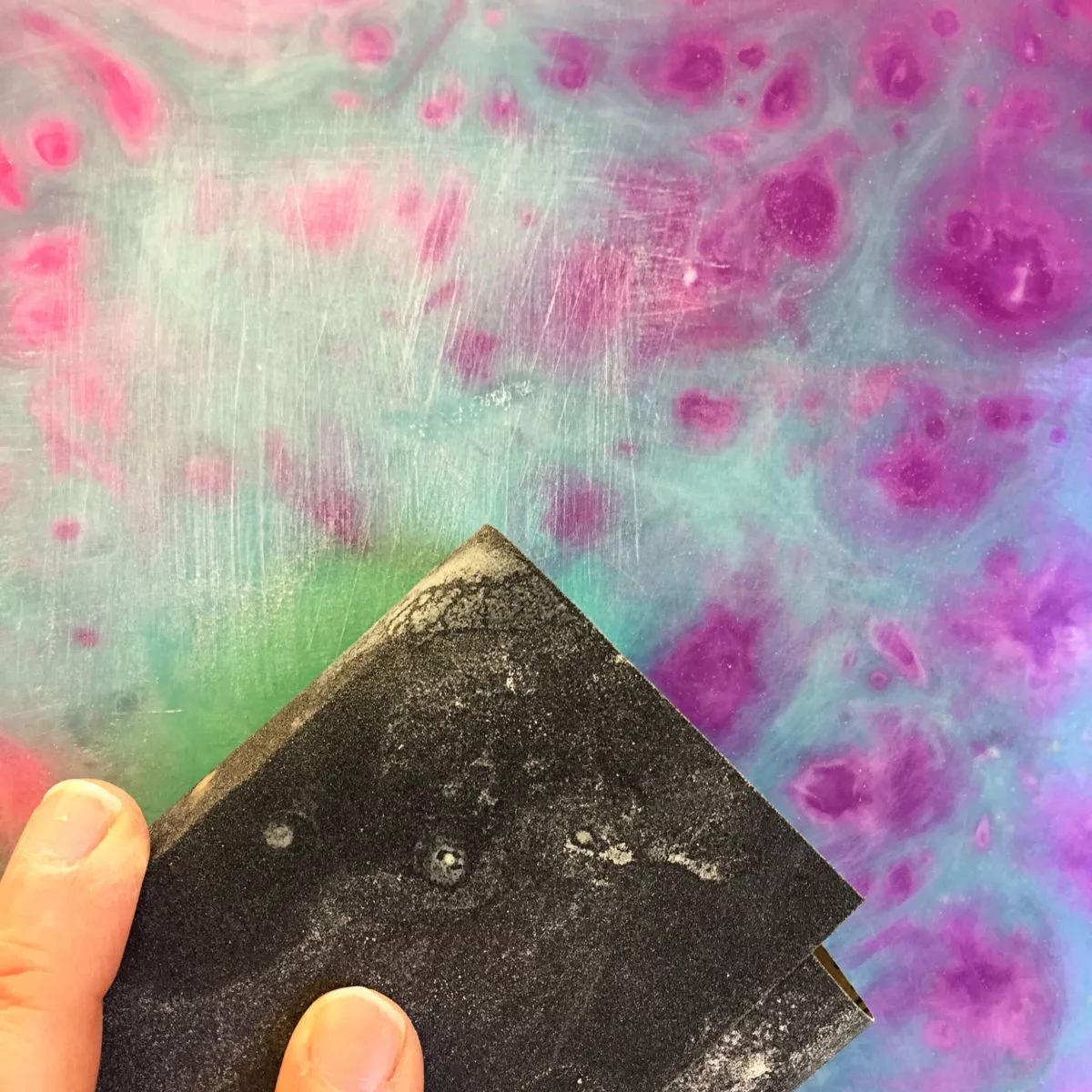 sanding a resin painting with wet dry sandpaper