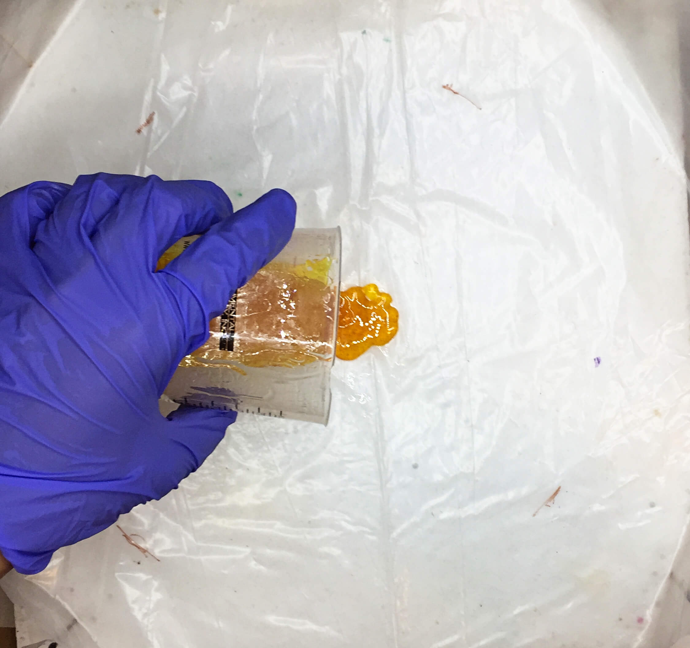 pouring yellow resin onto plastic
