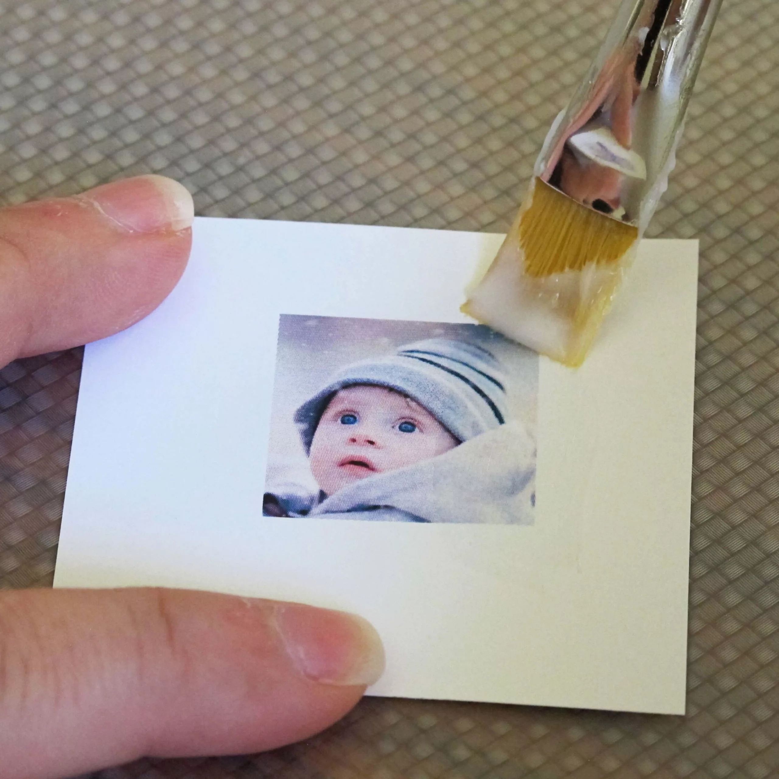 applying a layer of white glue to a photo