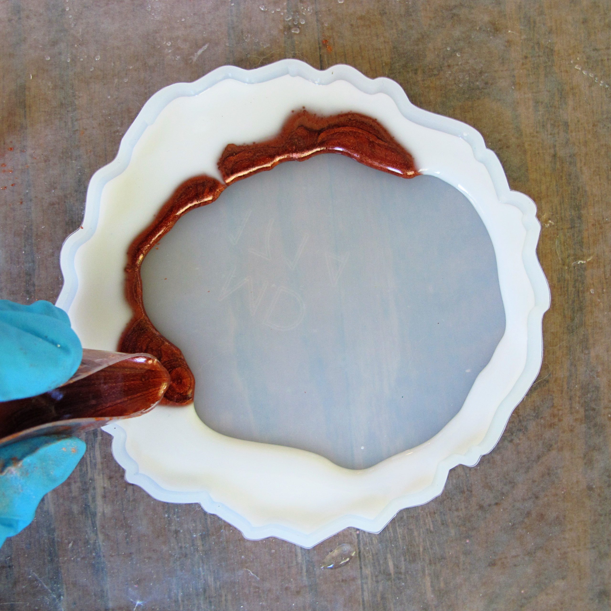 adding copper colored resin to silicone coaster mold