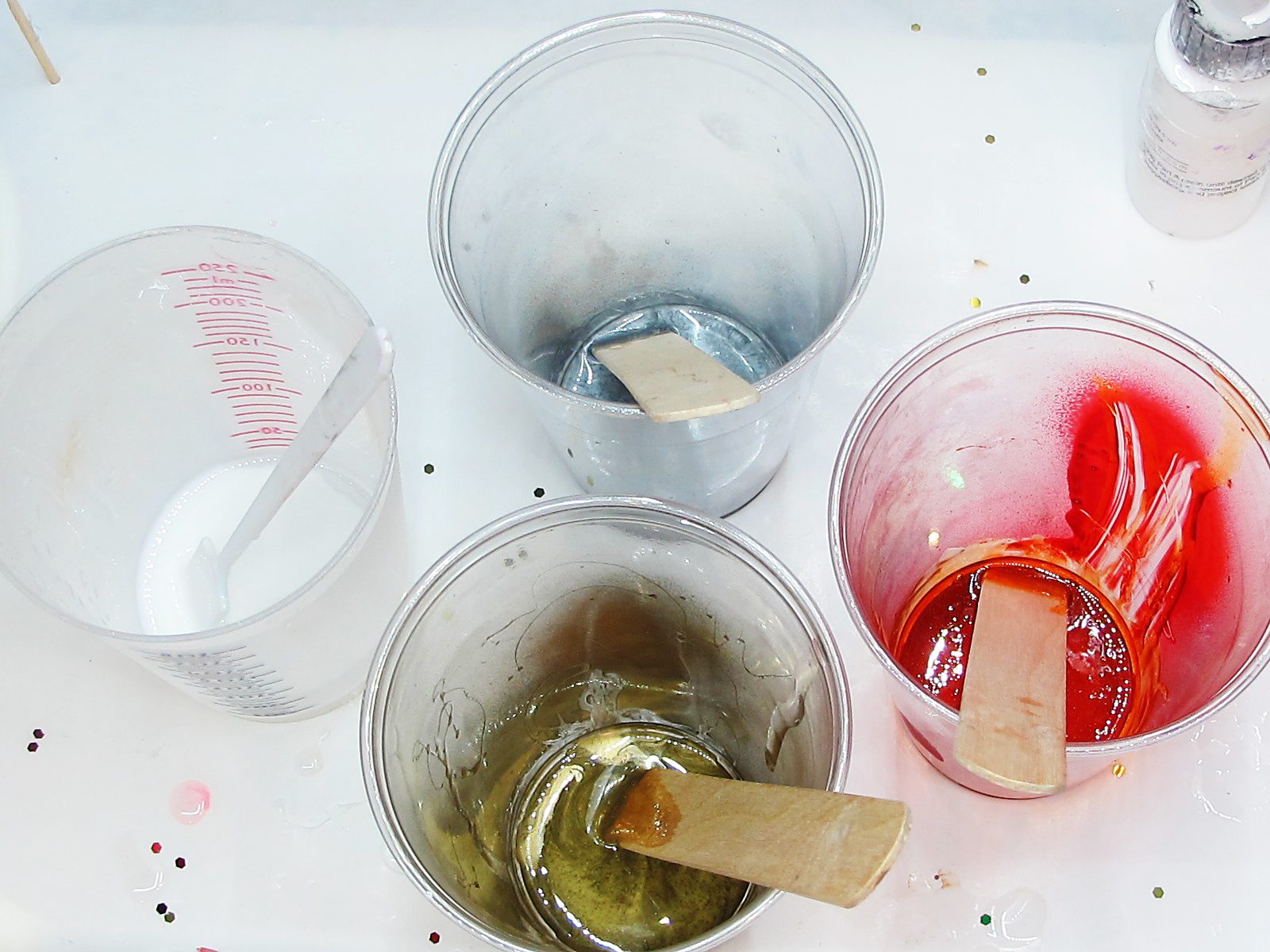  Four plastic cups with different colored resin.