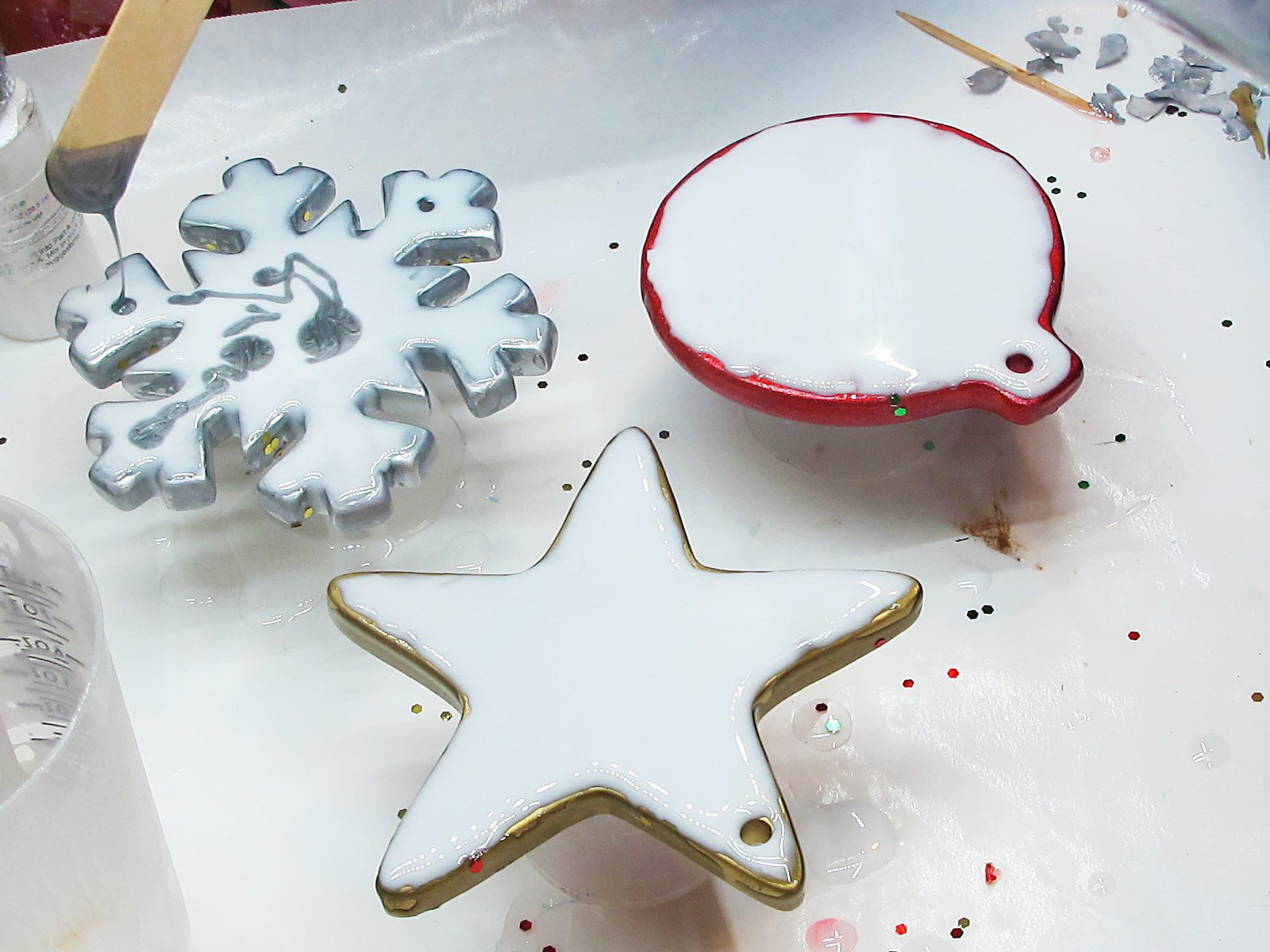 Poured white resin drying on Christmas ornaments.