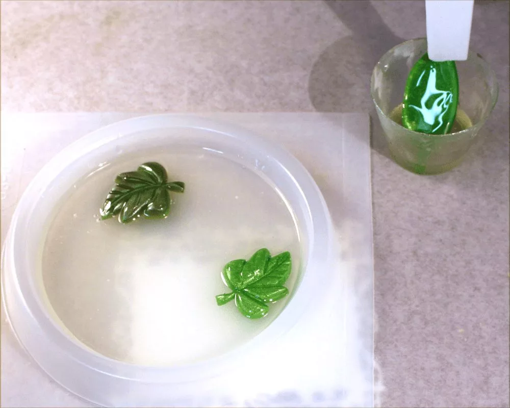 Adding leaves to a resin coaster mold.