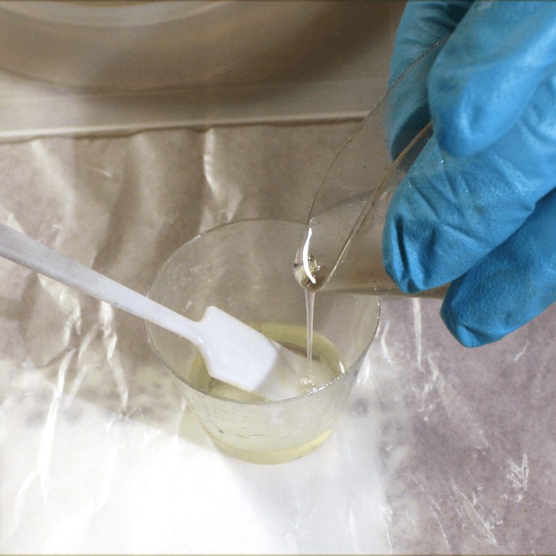 Pouring clear epoxy into a measuring cup