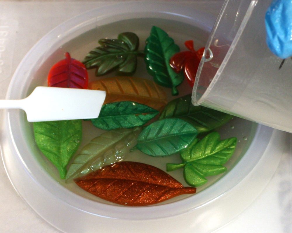 Pouring resin over leaves in a mold