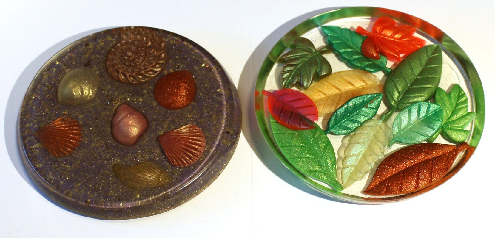Two resin coasters with leaves and seashells.
