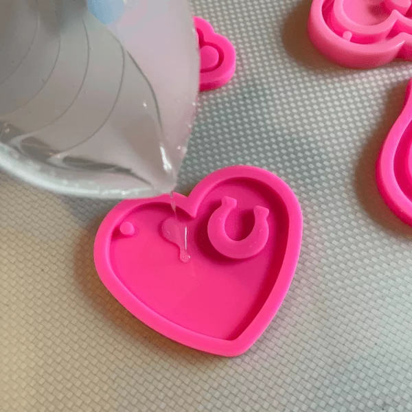 filling a silicone molds with clear epoxy resin
