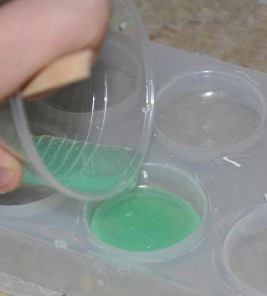 pouring sea green resin into circular molds