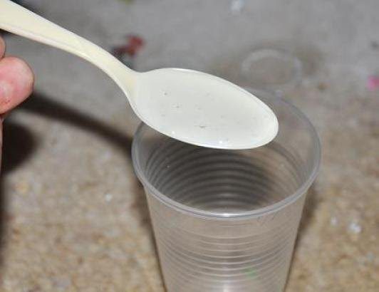 plastic spoon mixing resin in clear plastic cup