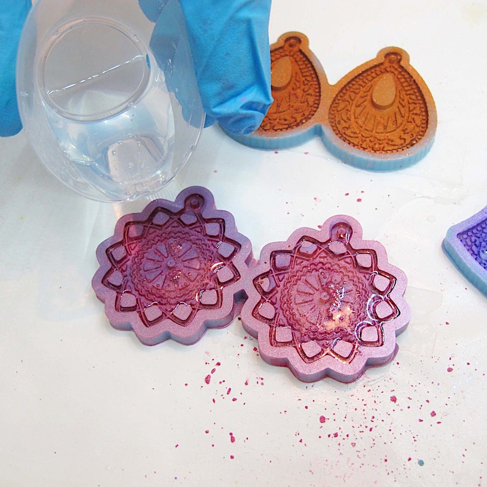 pouring clear resin into a boho earrings mold