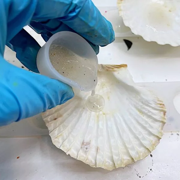 adding resin and sand to a shell