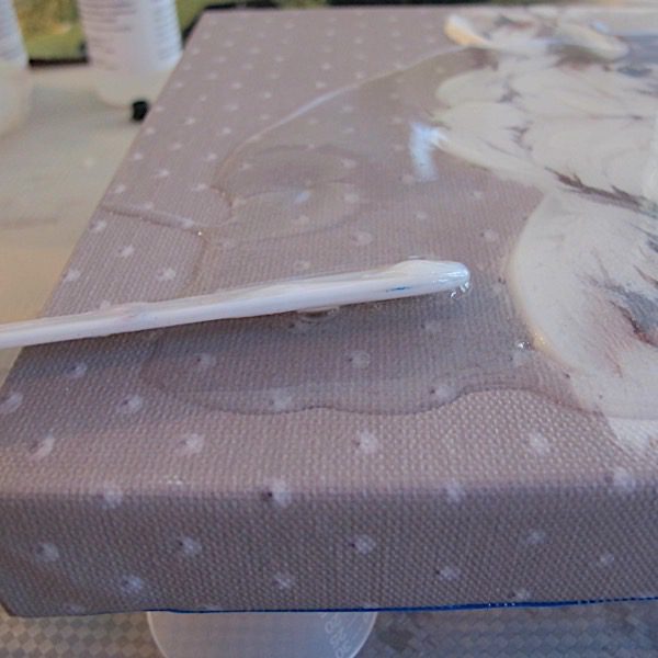 spreading resin over art canvas