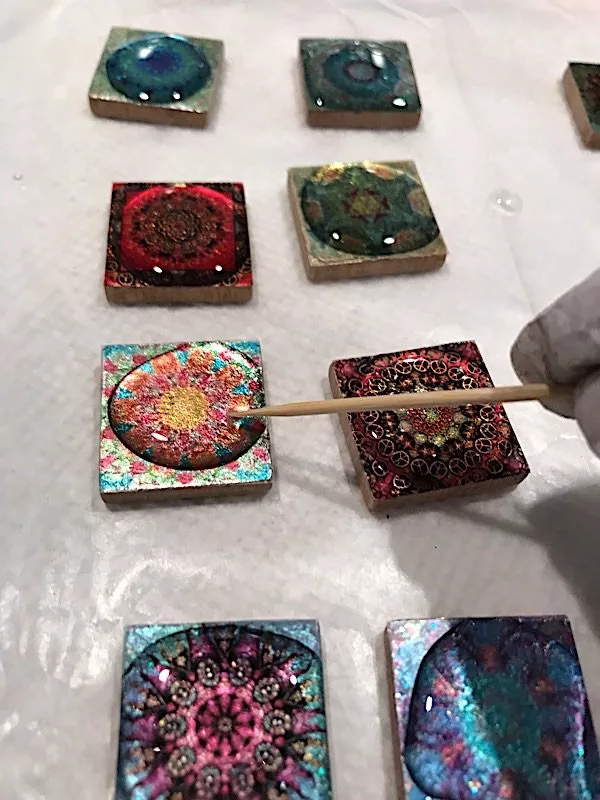 applying resin to mandala pendants